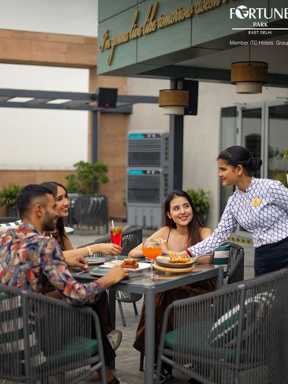Our staff is dedicated to making your experience seamless. Here, a guest is served with a smile at our rooftop restaurant, ensuring every detail of your meal is perfect.