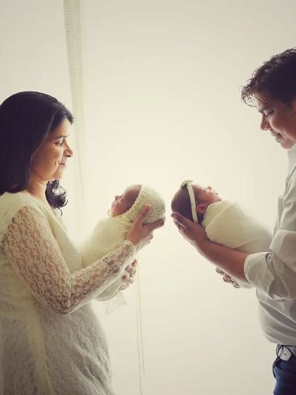 Another beautiful portrait of the family with their newborn twins. The soft, dreamy lighting enhances the magical feeling of welcoming two new lives into the world.