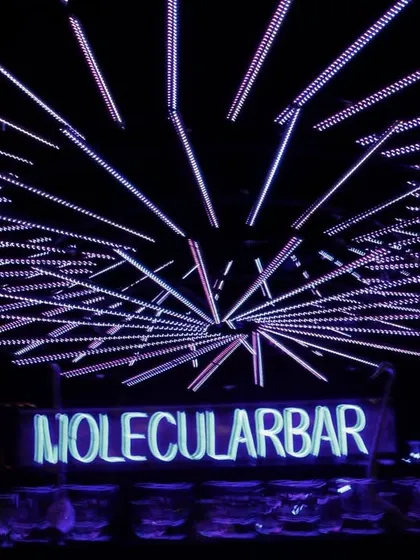The 'Molecular Bar' setup, with a custom neon sign and a ceiling of radiating light tubes, making the bar area a central feature of the Sangeet's design.