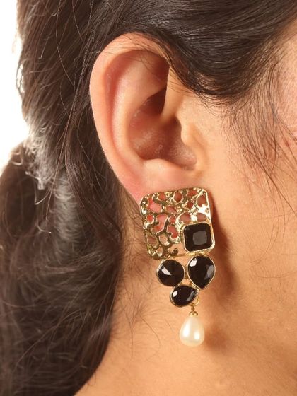 A model wearing our golden filigree stud earrings in black. At only 8 grams, they are lightweight and perfect for festive occasions.