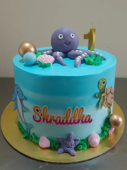 An "Under the Sea" cake for a first birthday, topped with a friendly fondant octopus and surrounded by other sea creatures.