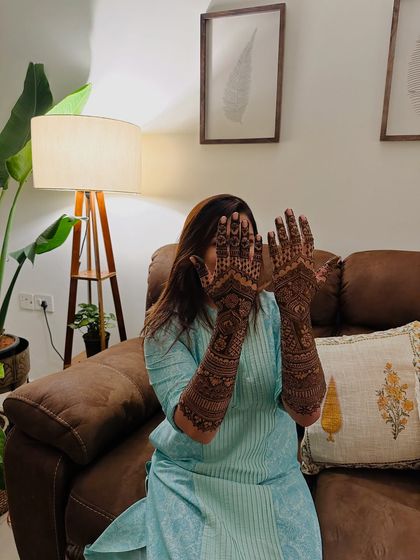 A playful pose that highlights the intricate patterns covering the bride's hands and arms.