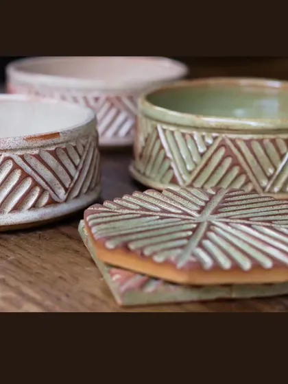 These lidded jars and coasters are part of the KHUMĀR collection. The carving is consistent across all pieces, making it a cohesive set for hosting.