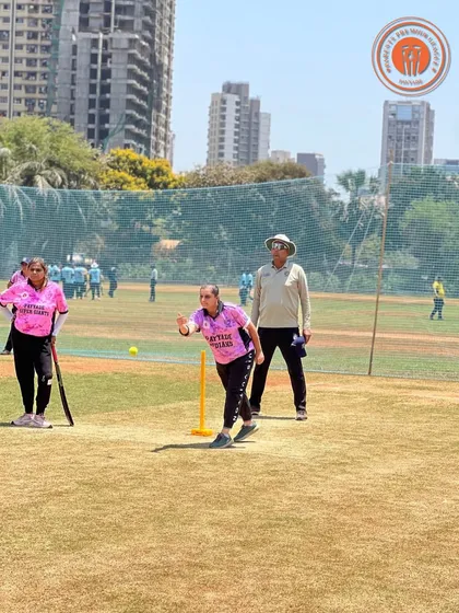 A woman in a pink jersey bowls with determination during a Parents Premier League match.