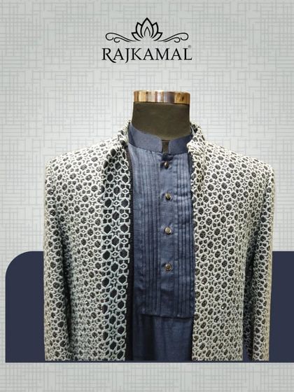 A black and white patterned Indo-Western jacket layered over a navy blue pintuck kurta. A sophisticated blend of patterns and textures.