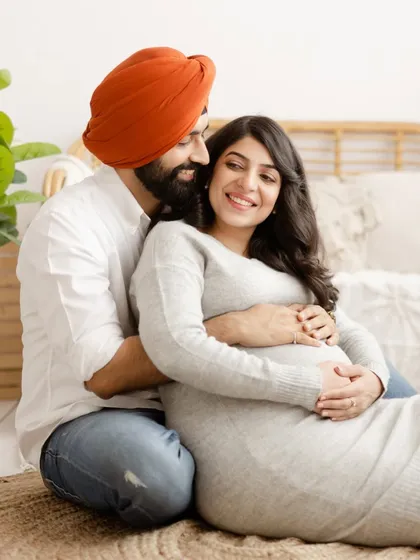 A cozy and intimate portrait of an expecting couple in our boho-themed studio. The warm smiles and gentle embrace perfectly capture the excitement of their journey.