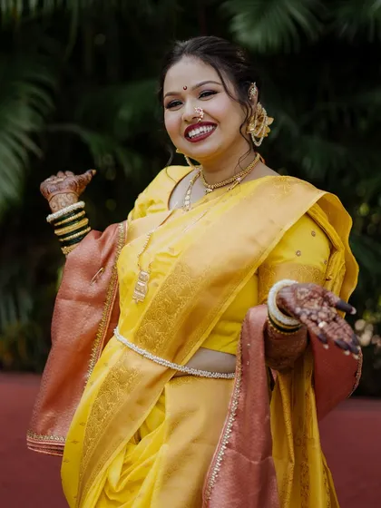 A playful and happy shot of the bride in her yellow Nauvari saree.