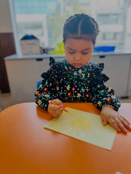 In our Speech & Drama program, children find new ways to express themselves. This moment of intense focus as a child draws shows how we encourage creativity and concentration, which are key skills for building confidence in communication.