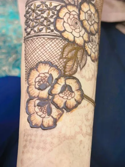 A close-up of a floral band on the arm. The shading technique used here gives the flowers a three-dimensional appearance.