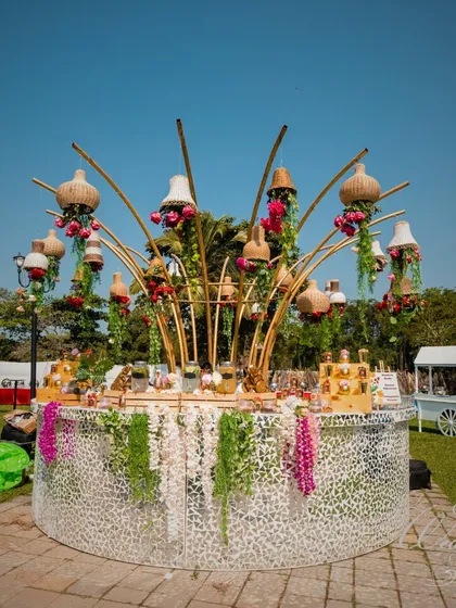 The bar at this Mehendi was a centerpiece in itself. The circular mirror-paneled bar is topped with an artistic arrangement of bamboo, lampshades, and florals, making it both functional and a decor statement.