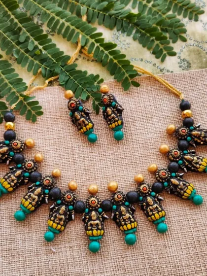 This is another color variation of my Mahalakshmi temple necklace, featuring sea-green accents instead of dark green. The antique gold finish remains, giving it a classic, heirloom quality.