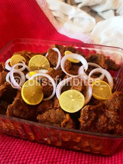 My Indian-style Steak, also known as Phaal. These are tender pieces of mutton cooked in a thick, spicy masala, served with fresh onion rings and lemon.