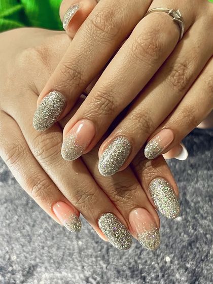 Can we talk about these nails? This stunning design features a reverse French manicure with a full-coverage silver glitter.
