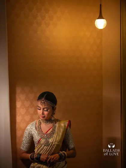 A duplicate of image 98, a contemplative portrait of a bride in her gold saree and custom blouse.