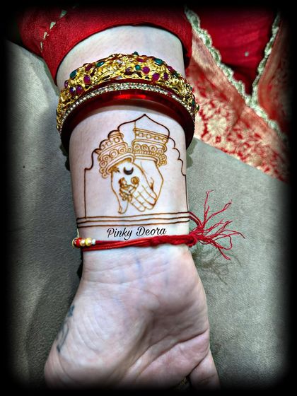 A minimal yet meaningful Karwa Chauth design on the wrist, showing the ritual of looking at the moon.