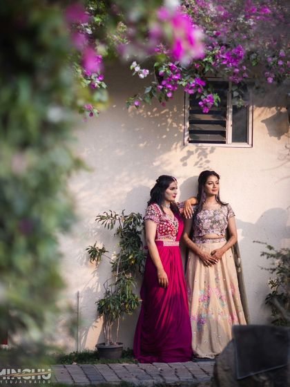 The bride and her bridesmaid posing together. It's always fun to coordinate looks while letting each personality shine through.