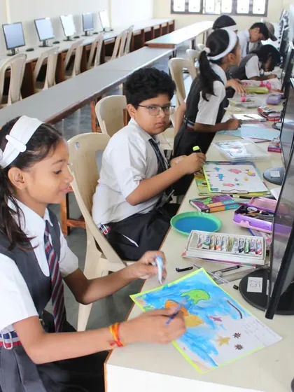 Two students work side-by-side on their drawing and coloring entries for the 2023 National Olympiad.