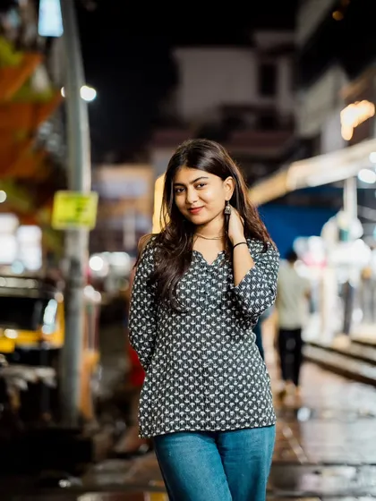 A confident and engaging pose. The way she's holding her hands and looking at the camera is very natural.