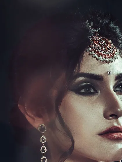 For me, accessory photography is about creating an entire mood. This close-up highlights the intricate design of a traditional maang tikka, using dark, contrasting light to draw attention to the piece and the model's expressive eyes.