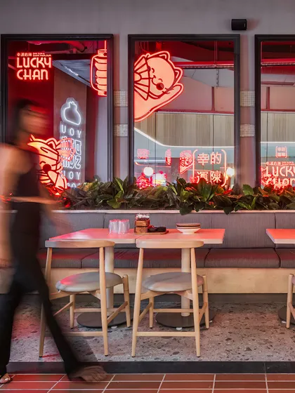 We used backlit mirrors featuring the 'Lucky' cat mascot to add a layer of brand storytelling. The red neon glow creates a dynamic and engaging visual element along the main seating bank.