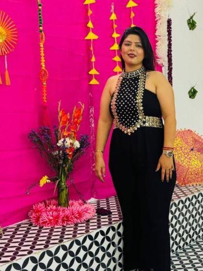 A full standing pose in the black jumpsuit, showing its elegant silhouette.