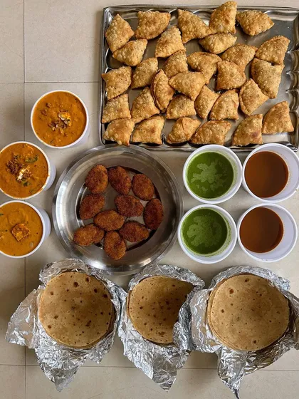A platter of mini samosas, veg cutlets, and paneer curry, perfect for a small gathering.