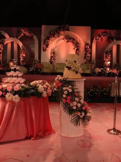 The cake and champagne tower are key moments in any reception. I designed this stage area with a beautiful floral backdrop, placing the wedding cake on an elegant pedestal and a champagne tower on a draped table to create a perfect photo opportunity.