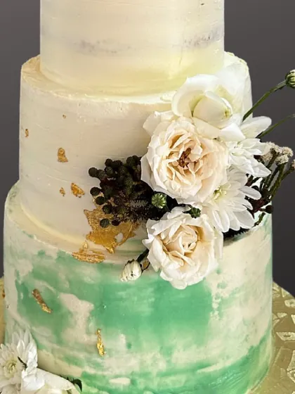A closer look at this season's first wedding cake. The semi-naked or 'demure' style is paired with a beautiful sage green watercolour effect and flecks of gold leaf for a touch of elegance.