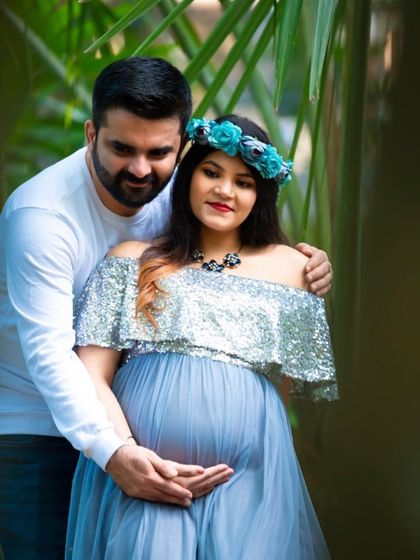 An intimate couple's portrait framed by nature. The lush green leaves create a natural frame, drawing focus to the couple's loving embrace.