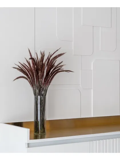 Details matter. The textured white wall paneling in the dining area serves as a subtle yet impactful backdrop, with a brass ledge adding a touch of metallic warmth.
