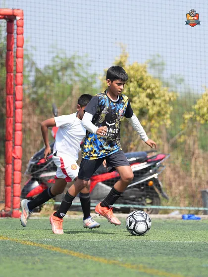 Battling for possession. This image captures the competitive spirit and determination of our youth players.