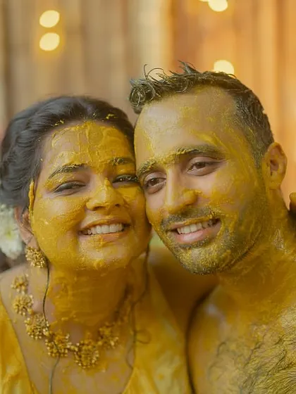 A happy, turmeric-covered couple posing for a photo after their Haldi ceremony in Goa. Their smiles are everything.