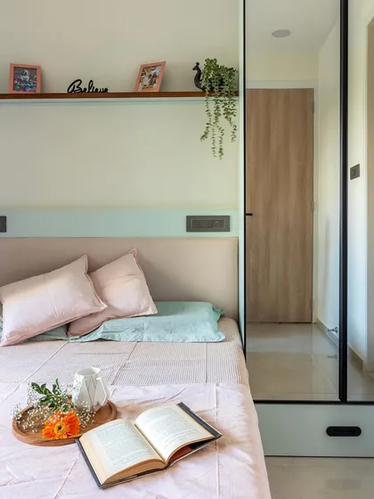 A detail shot of this bedroom, where a floating shelf above the headboard provides a space for personal touches without adding clutter.