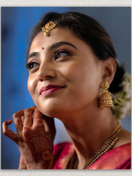 A beautiful close-up of the bride, Ramya, highlighting her traditional jewelry and the happy, gentle look in her eyes.