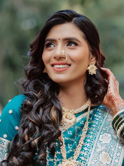 A close-up on the bride's radiant smile. Her makeup features a soft wing liner and a warm lip, perfect for a traditional yet modern engagement look.