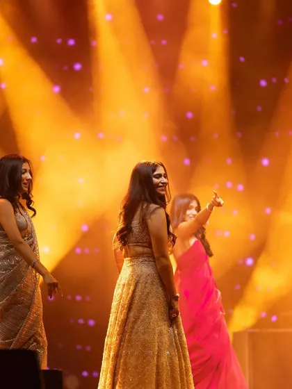 Capturing the fun and camaraderie of a bridesmaid performance. The warm, golden lighting and candid smiles make this a perfect memory of the bride enjoying her sangeet with her best friends.
