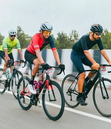 Three elite riders in a tight formation, a common sight in the final kilometers of a race as they prepare for the sprint.
