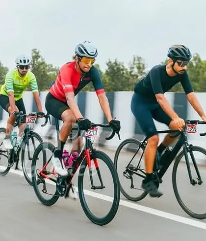 Three elite riders in a tight formation, a common sight in the final kilometers of a race as they prepare for the sprint.