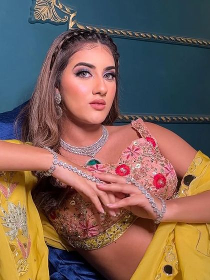 A relaxed and stylish pose in the floral lehenga, highlighting the diamond-look jewellery and the vibrant yellow dupatta.