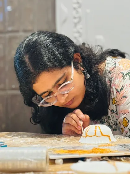 A participant carefully applies the golden lacquer to a repaired bowl. This close-up shows the delicate, mindful process of Kintsugi, where every crack is highlighted as a part of the object's history.