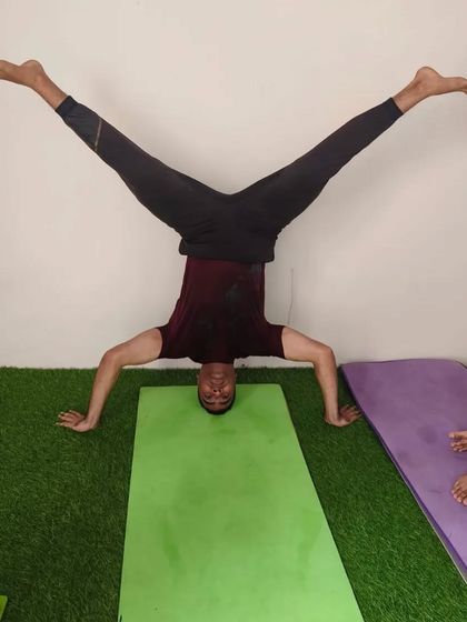 A wide-legged split in a headstand with wide hands. This variation challenges balance and flexibility at the same time.