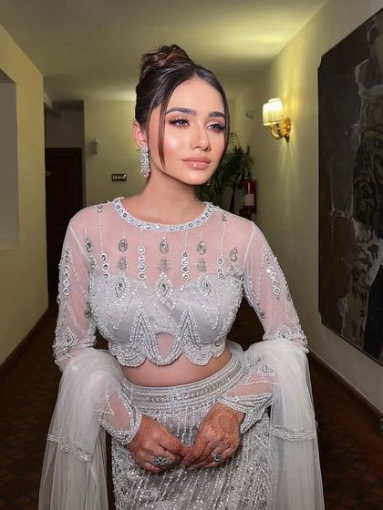 Daydreaming in a silver-grey gown with intricate beadwork and bell sleeves.