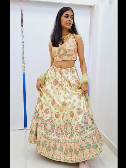 This pastel green lehenga features beautiful multi-color thread embroidery in shades of pink and peach. It's a light, fresh, and elegant option for a day function.