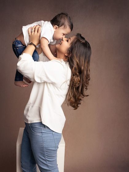 A mother lifts her baby boy high in the air, sharing a moment of pure joy and laughter. These candid, playful shots are filled with so much life.
