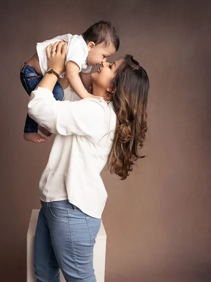 A mother's joy as she lifts her baby boy into the air. His little smile and her loving gaze make this a perfect, heartwarming shot.