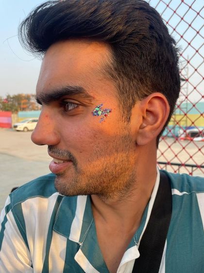 A multi-colored glitter design on a male client. The mix of blue, green, and purple creates a cool, galaxy-like effect.