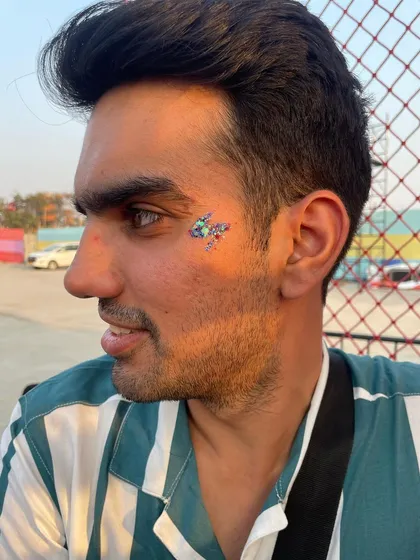 A multi-colored glitter design on a male client. The mix of blue, green, and purple creates a cool, galaxy-like effect.