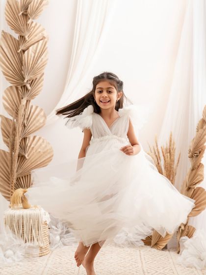 In her dreamy world. A young girl twirls in her beautiful white dress, her movement and joy captured perfectly.
