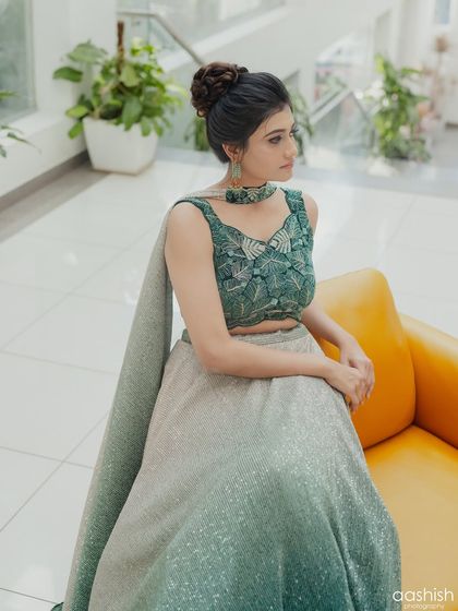 A full-length shot of the client, showing the beautiful ombre effect of her lehenga skirt and the elegant silhouette of her outfit.