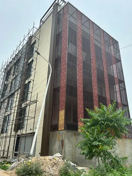 A 250 sq. yard builder floor under construction in Faridabad, featuring a unique perforated metal screen (jaali) on the facade. This screen adds a decorative element while also providing privacy and shade.